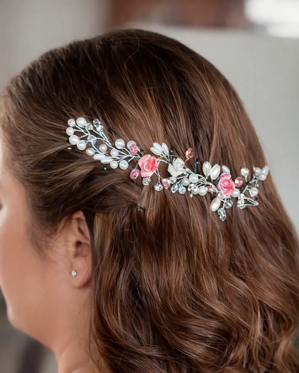 Tocado con perlas blancas, flores rosadas y detalles brillantes en estructura plateada